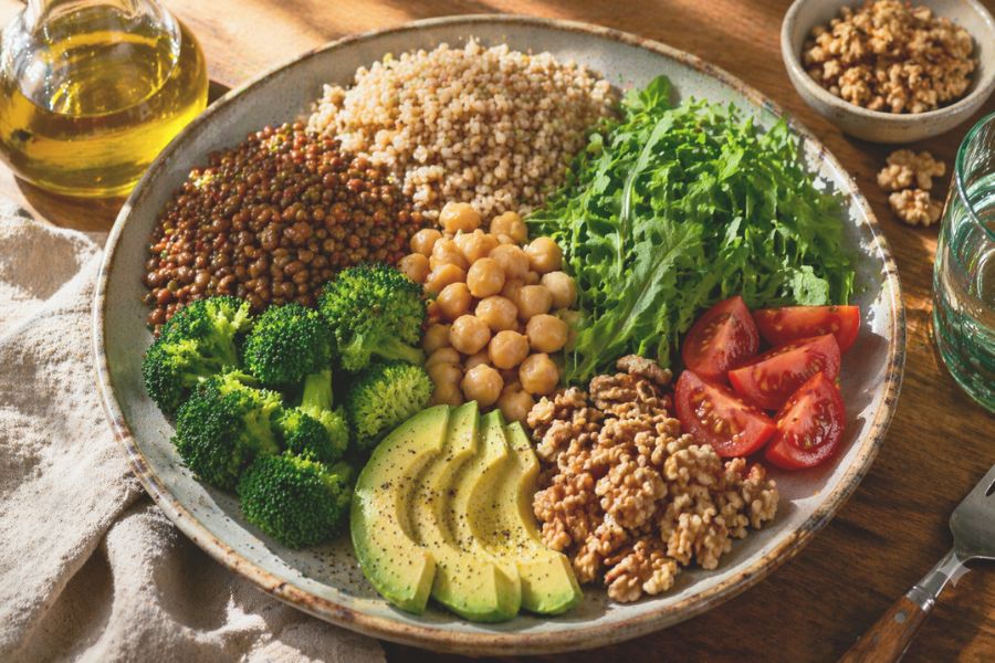 Piatto equilibrato con legumi, verdure, cereali integrali e grassi sani consigliato per il colesterolo alto