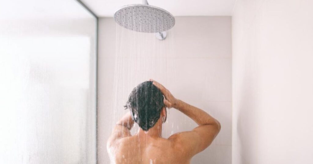Uomo adulto in bagno durante la routine di igiene personale quotidiana